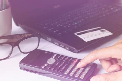 Man's hands using calculator for online shopping and credit card over lapto.. Stock Photos