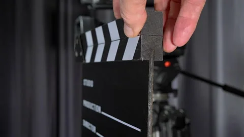 Man's hands using a clapperboard in front of a studio video camera. Stock Footage 221233744