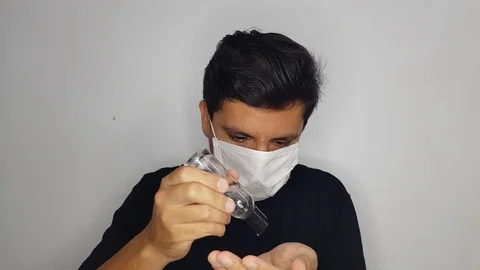 A man's hands using hand sanitizer to reduce the risk of getting and spreading Video stock 126307032