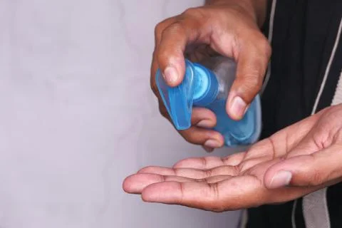 Man's hands using hand sanitizer gel, close up Stock Photos