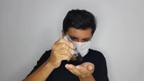 A man's hands using hand sanitizer to reduce the risk of getting and spreading Stock Photos