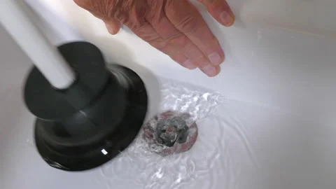 Man's hands using a plunger on a bathroom sink. Video stock 195625827