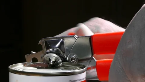 Man’s hands using a red and chrome tin opener on a can of chopped tomatoes. Video stock 104058318
