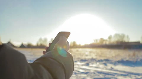 Man's hands using smart phone in winter against beautiful sunset Stock Footage 58362643
