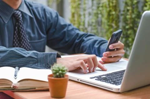 Man's hands using smart phone . view of business man hands busy using cell .. Stock Photos