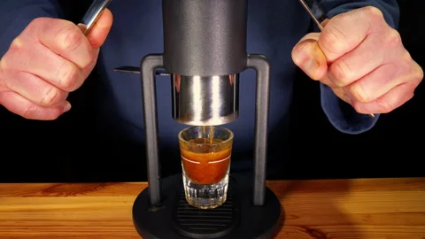 Man’s hands using twin levers of a manual machine to deliver an espresso shot. Stock-Footage 233586765