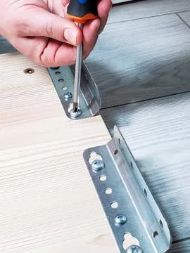 The man's hands working with a screwdriver. Assembly of furniture Stock Photos
