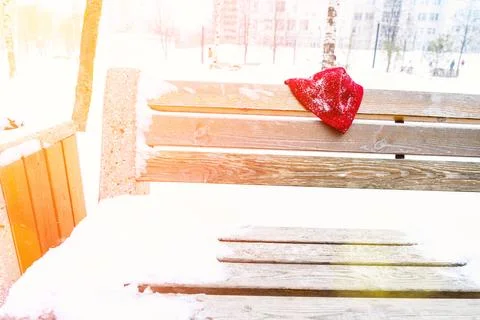A man's hat is forgotten on a park bench in winter Stock Photos