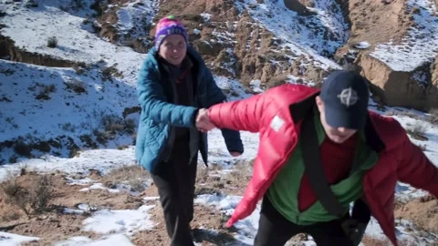 A man's help to a girl to overcome a difficult section while climbing Vídeo Stock 236450074