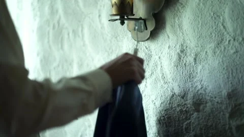 Man’s jacket hanging on white wall. Groom takes jacket. Wedding day Stock Footage 139528807