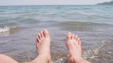 Mans legs on beach with sea waves 库存影片 112757229