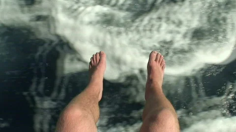 Mans legs hanging over the side of a boat Stock Footage 84785