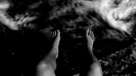 Mans legs hanging over the side of a boat.  Stock Footage 590400