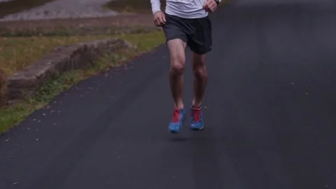 Man's Legs Running Down Road During Evening Stock Footage 81529944