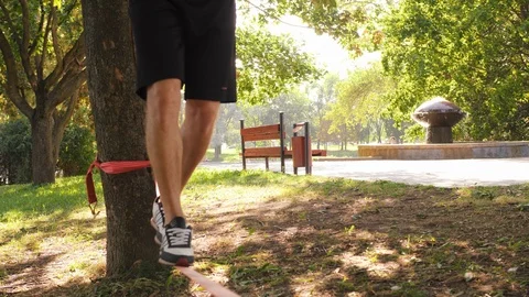 Man's legs witch balancing on the slackline and making a step. 4K slow mo Stock Footage 98765277