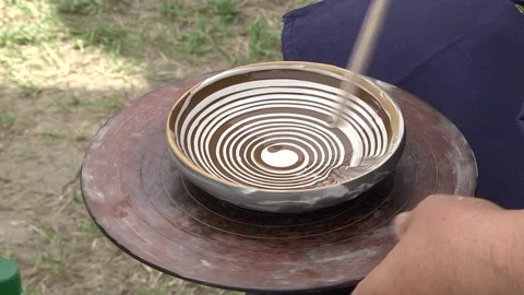 Man's mine decorating a ceramic vessel with shades of brown with a stick wit Stock Footage 146542897