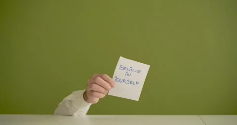 The man's mini picks up a sheet where it is written Believe in Your Self Stock Footage 267091015