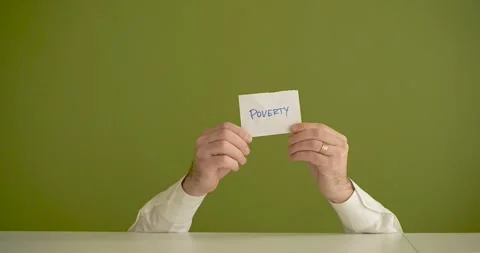 The man's mini picks up a sheet where it is written Poverty Stock Footage 267092260