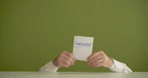 The man's mini picks up a sheet where it is written Subscribe Stock Footage 267092888