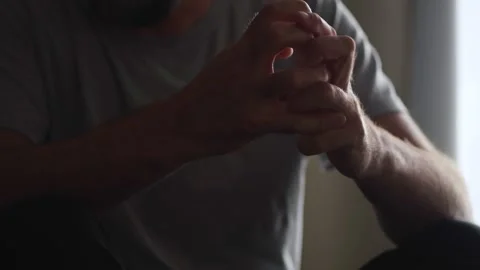 A man's nervous hand gestures in a dim room portray his mental anguish and .. Video stock 273697569