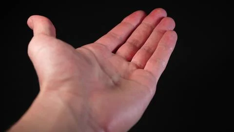 A man's outstretched hand on a dark background Stock Photos