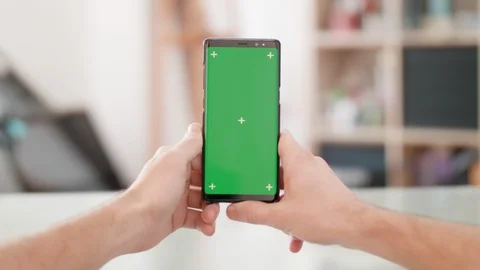 Man;s point of view holding a smartphone vertically with green screen on in the Stock Footage 105706482