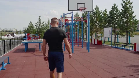 Man's pulls himself up on the horizontal bar. Outdoor sports. An athlete in blue Stock Footage 135436856