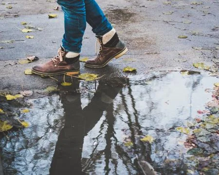 A mans reflection in a puddle walking by. Stock-Fotos