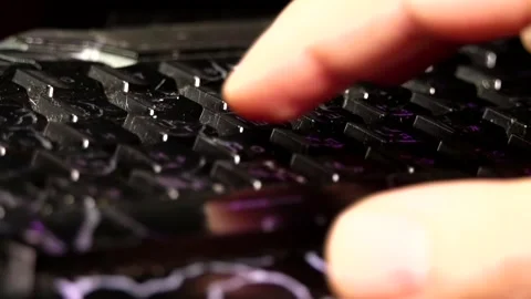 A man's right hand fingers typing on a black, glowing keyboard close-up Stock Footage 342256256