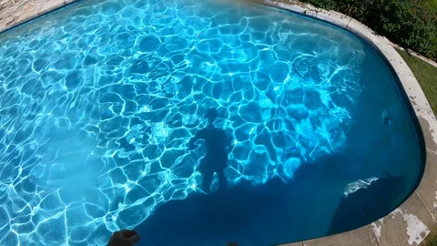 Man's Shadow Jumps Into Pool 4K Slow Motion Stockbeeldmateriaal 129730150