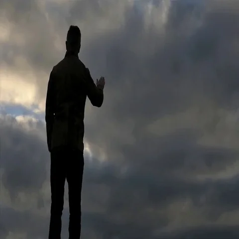 Man's silhouette dissolving on sky background slow motion Stock Footage 69608738