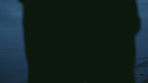 Man's silhouette walking through frame from left to right in the evening or at Video stock 93696037