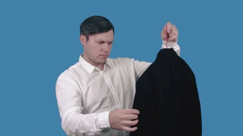A man's suit. A man hangs a jacket on a hanger. Stock Footage 148445615