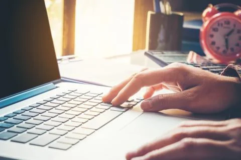 Man's using laptop with blank screen on desk in home interior. Business conce Stock Photos