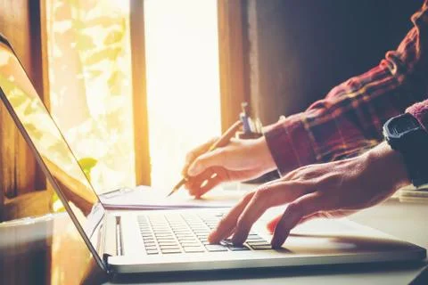 Man's using laptop with blank screen on desk in home interior. Business conce Stock Photos