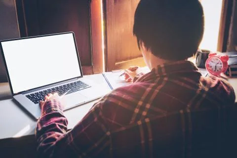 Man's using laptop with blank screen on desk in home interior. Business conce Stock Photos