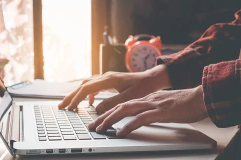 Man's using laptop with blank screen on desk in home interior. Business conce Stock Photos