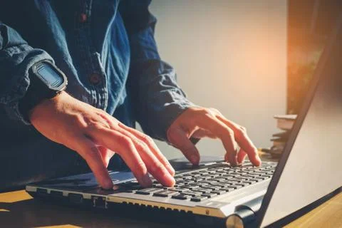 Man's using laptop with blank screen on desk in home interior. Business conce Stock Photos