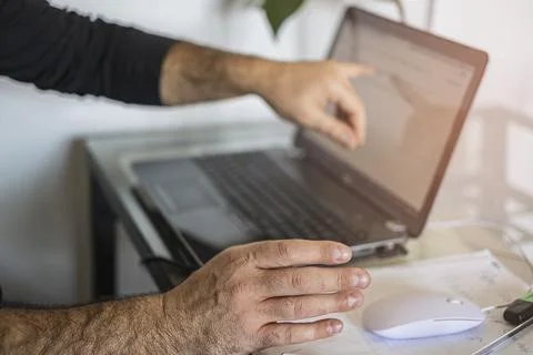 A man's using laptop hand on mouse and shows the screen Stock Photos