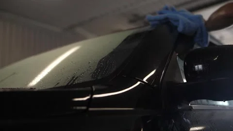 Man's worker hand wiping car headlight in car washing service. Stock Footage 262546283