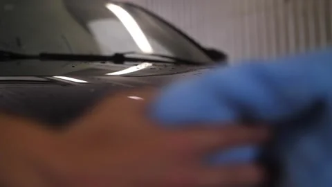 Man's worker hand wiping car headlight in car washing service. Stock Footage 262546307