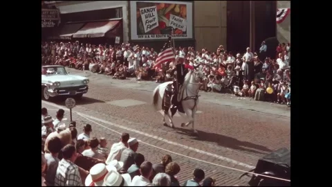 MANSFIELD - 1958 - A large crowd gather along a city street to watch a street Stock Footage 340658598