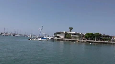 Mansion at end of island in harbor with small motor boat passing in the chann Video stock 67491153