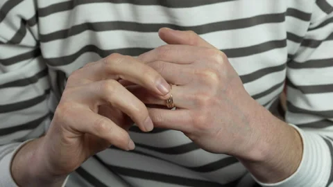A mantwists his wedding ring on the finger of his left hand. Stock Footage 306934997