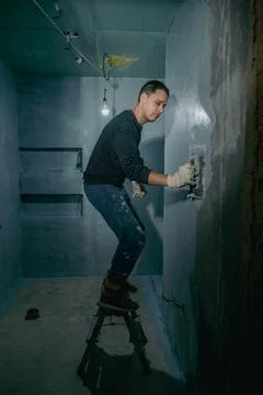 Manual application of waterproofing to the wall on the construction site Stock-Fotos
