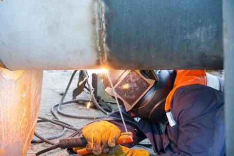 Manual arc welding. A professional welder welds a pipe with a diameter of Du6 Stock Photos