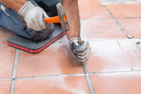 Manual demolition of ceramic flooring using a hammer and metal chisel befor.. Stock Photos