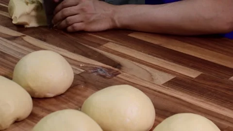 Manual Dough Forming for Artisan Bread Rolls in Kitchen Setting Stock Footage 332621993