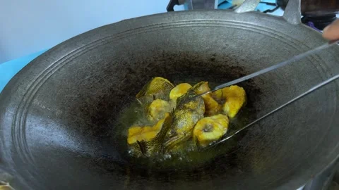 Manual Fish Frying Process Using Metal Tongs Stock Footage 328487093