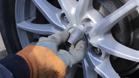Manual installation of the bolt on the machine disk Stock Photos
